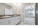 Bright bathroom featuring double vanity with stone countertop and large mirror at 13423 Crest Lake Dr, Hudson, FL 34669