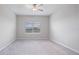 Serene bedroom with plush carpet, ceiling fan, and a window overlooking the outdoors at 13423 Crest Lake Dr, Hudson, FL 34669