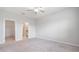 Spacious bedroom with carpet flooring, fan, and connecting bath and closet at 13423 Crest Lake Dr, Hudson, FL 34669