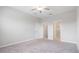 Bright bedroom with carpet flooring, fan, and access to bath and closet at 13423 Crest Lake Dr, Hudson, FL 34669
