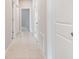 Bright hallway with tile flooring, white doors, and neutral-toned walls leading to other areas of the home at 13423 Crest Lake Dr, Hudson, FL 34669