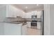 Modern kitchen featuring stainless steel appliances, granite countertops, and white cabinets at 13423 Crest Lake Dr, Hudson, FL 34669