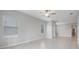 Bright living room with ceiling fan, tile flooring, and lots of natural light from large windows at 13423 Crest Lake Dr, Hudson, FL 34669