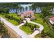 Gorgeous aerial view showcases a luxurious estate with manicured landscaping, circular driveway, and a serene lake backdrop at 17124 Crawley Rd, Odessa, FL 33556