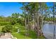 Expansive backyard featuring a lush lawn, winding path, and lake view with a charming gazebo on the water at 17124 Crawley Rd, Odessa, FL 33556