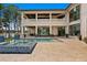 Expansive backyard oasis with infinity pool, spa, covered patios, and lush landscaping overlooking a picturesque lake at 17124 Crawley Rd, Odessa, FL 33556