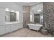 Bright bathroom featuring a standalone tub, mosaic tile wall, and double vanity with large mirror at 17124 Crawley Rd, Odessa, FL 33556