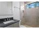 Modern bathroom featuring stone-look tile, granite countertops, and a frameless glass shower at 17124 Crawley Rd, Odessa, FL 33556