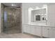 Bathroom featuring walk-in shower with glass door, and a vanity with countertop and large mirror at 17124 Crawley Rd, Odessa, FL 33556