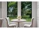 Cozy breakfast nook area with a round table and chairs set in front of scenic views of the landscaped yard at 17124 Crawley Rd, Odessa, FL 33556