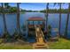 Picturesque wooden dock and gazebo extending into a serene lake, framed by tall cypress trees along the shoreline at 17124 Crawley Rd, Odessa, FL 33556
