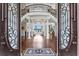 Grand foyer with intricate door design, soaring staircase, and an elegant chandelier at 17124 Crawley Rd, Odessa, FL 33556