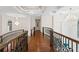 Upstairs hallway boasts wood floors, decorative chandeliers, and an ornate railing at 17124 Crawley Rd, Odessa, FL 33556