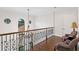 Upper hallway featuring wood flooring, a chandelier and wrought iron railings at 17124 Crawley Rd, Odessa, FL 33556