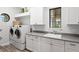 Laundry room with front loading washer and dryer, cabinets, and granite countertop at 17124 Crawley Rd, Odessa, FL 33556