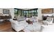 Comfortable living room features a neutral color scheme, plush seating, and serene views of the pool and lake at 17124 Crawley Rd, Odessa, FL 33556