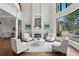 Spacious living room with a cozy fireplace, high ceilings, and beautiful water views through expansive windows at 17124 Crawley Rd, Odessa, FL 33556