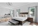 Bright bedroom with hardwood floors, sitting bench and dark wood furnishings at 17124 Crawley Rd, Odessa, FL 33556