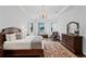 Spacious bedroom featuring a chandelier, tray ceiling, and water view from the windows at 17124 Crawley Rd, Odessa, FL 33556
