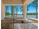 Well-equipped outdoor kitchen with stainless steel appliances and granite countertops, perfect for lakeside entertaining at 17124 Crawley Rd, Odessa, FL 33556