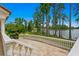 Spacious outdoor patio featuring elegant stone balustrade with tranquil lake views surrounded by mature trees at 17124 Crawley Rd, Odessa, FL 33556
