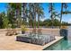 Gorgeous backyard with tiled spa and in-ground pool overlooking a peaceful lake on a sunny day at 17124 Crawley Rd, Odessa, FL 33556