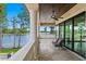Covered porch showcases stone floors, decorative columns and peaceful water view at 17124 Crawley Rd, Odessa, FL 33556