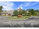 A circular drive and manicured garden lead to the gorgeous Clubhouse with an American flag on the roof at 17318 Emerald Chase Dr, Tampa, FL 33647