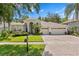 Charming single-story home featuring a three-car garage, paver driveway, manicured lawn and lush landscaping at 17318 Emerald Chase Dr, Tampa, FL 33647