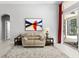 Neutral living room featuring beige sofa, abstract painting, and large sliding doors to the exterior at 17318 Emerald Chase Dr, Tampa, FL 33647