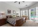 Bright main bedroom with a ceiling fan, large window, and glass door to the outdoor pool at 17318 Emerald Chase Dr, Tampa, FL 33647