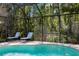 Close-up of chairs in serene screened-in pool area, surrounded by lush landscaping and privacy at 17318 Emerald Chase Dr, Tampa, FL 33647