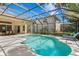 Sparkling screened-in pool with ample patio space and view of backyard and the home's exterior at 17318 Emerald Chase Dr, Tampa, FL 33647