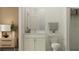 Cozy bathroom features a single sink vanity with modern finishes and hardware, alongside a nearby bedroom dresser at 18461 Serene Lake Loop, Lutz, FL 33548