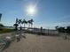Brick patio with sun loungers, palm trees, and distant water views with clear blue sky at 1898 Shore S Dr # 311, South Pasadena, FL 33707