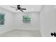 Well-lit bedroom has hardwood floors, a ceiling fan, and a window with blinds offering a view of the outdoors at 1914 E Emma St, Tampa, FL 33610