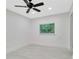 Well-lit bedroom boasts a ceiling fan, a window with blinds, and clean, neutral decor with hardwood flooring at 1914 E Emma St, Tampa, FL 33610