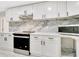 Stylish kitchen features sleek stainless appliances, quartz countertops and backsplash, and modern white cabinets at 1914 E Emma St, Tampa, FL 33610