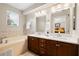 Bathroom featuring a dual sink vanity, tub, and decorative tile accents at 20039 Heritage Point Dr, Tampa, FL 33647