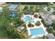 Aerial view of community pools, splash pad, poolside seating, cabana, and playground in lush landscaping at 20039 Heritage Point Dr, Tampa, FL 33647