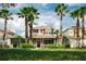 Charming two-story home with front porch and lush landscaping under a partly cloudy sky with palm trees at 20039 Heritage Point Dr, Tampa, FL 33647