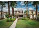 Charming two-story home with lush landscaping, inviting front porch, and beautiful palm trees at 20039 Heritage Point Dr, Tampa, FL 33647