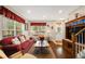 Cozy living room with a large window, a red sofa with decorative pillows, wood flooring, and stairs to the second floor at 20039 Heritage Point Dr, Tampa, FL 33647