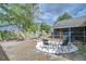 Landscaped backyard featuring stone patio with chairs and a partially screened patio at 2020 Elk Spring Dr, Brandon, FL 33511