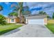 Inviting single-story home with a two-car garage, well-maintained lawn, and tropical landscaping at 2020 Elk Spring Dr, Brandon, FL 33511