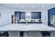 Bright kitchen features navy cabinets, stainless appliances, and a large island with quartz countertops at 2020 Elk Spring Dr, Brandon, FL 33511