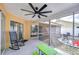 Covered patio features a rocking chair, large fan, and outdoor dining area at 2020 Elk Spring Dr, Brandon, FL 33511