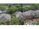 A high angle view of the townhomes, mature trees, and parking area creating a desirable community setting at 2220 Chianti Pl # 8-0828, Palm Harbor, FL 34683