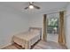 Cozy bedroom with natural light from the window, a ceiling fan, and light hardwood floors at 2220 Chianti Pl # 8-0828, Palm Harbor, FL 34683