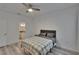Bedroom featuring a ceiling fan, wood-look flooring, and door leading to bathroom at 2220 Chianti Pl # 8-0828, Palm Harbor, FL 34683
